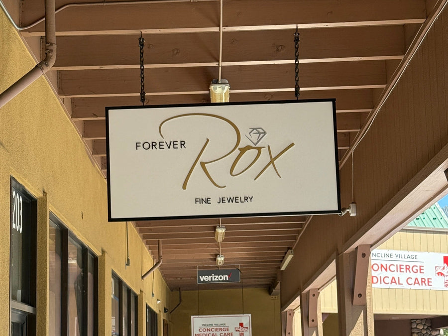 Forever Rox blade sign hanging in a covered walkway