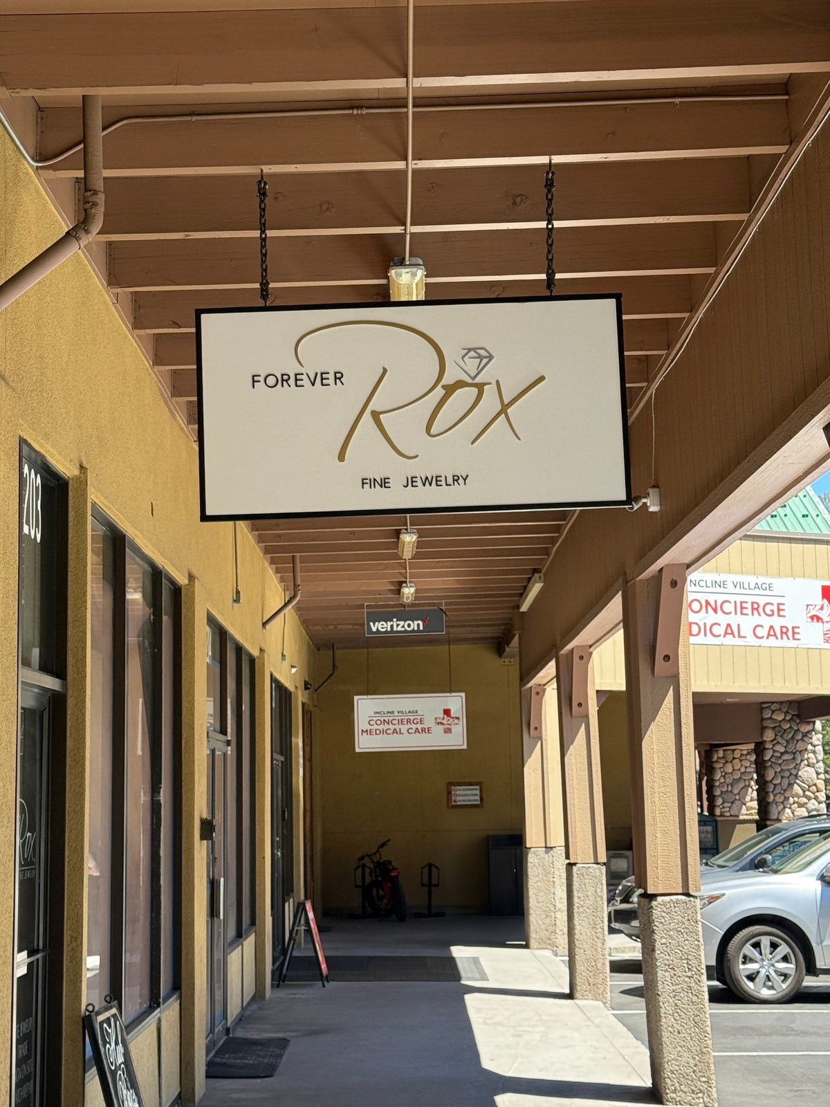 Hanging blade sign with raised gold script for Forever Rox Fine Jewelry