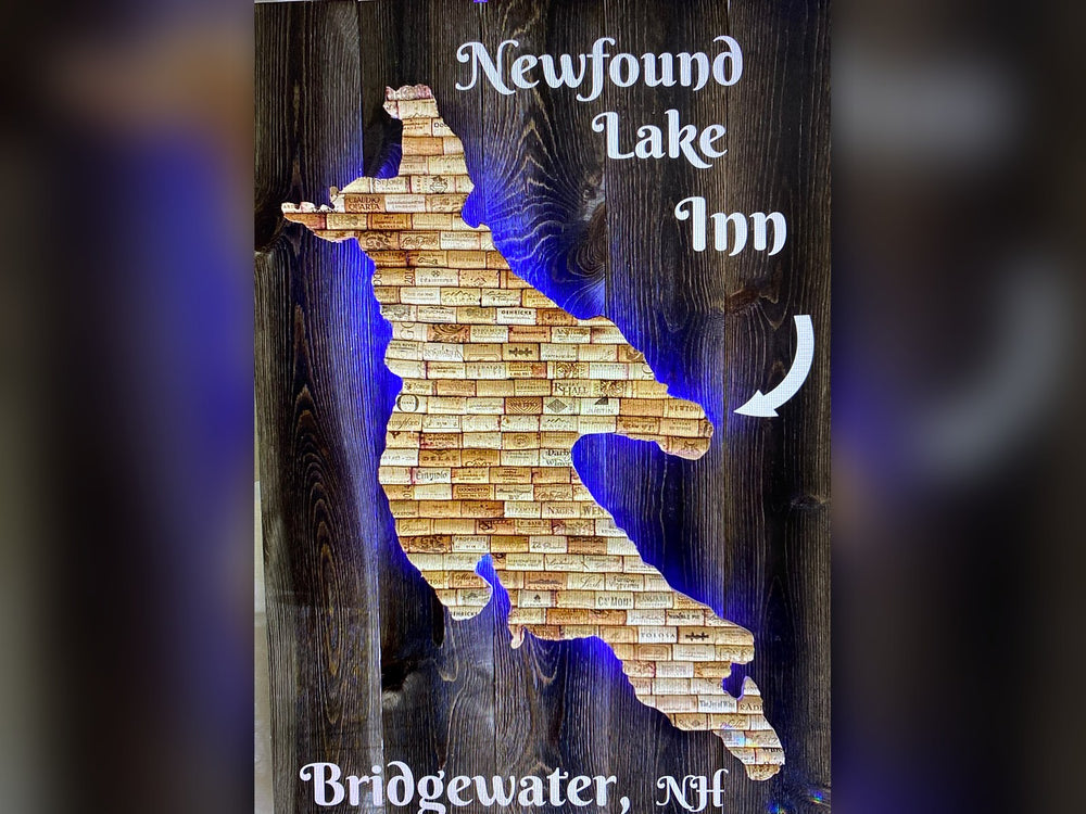 Newfound Lake made from wine corks on dark wood planks with blue backlighting, lettered Newfound Lake Inn, Bridgewater, NH